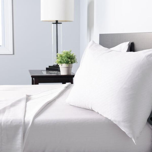 White striped Egyptian cotton pillow and bed sheets in a modern bedroom setting