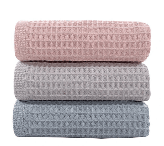Soft waffle weave bath towels in pink, gray, and blue for luxury bathroom comfort
