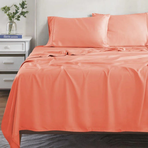 Coral Egyptian cotton bed sheets and pillowcases on a made bed, luxury bedding set