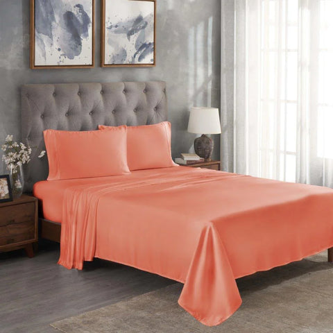 Coral Egyptian cotton bed sheets and pillowcases on a tufted gray headboard bed in modern bedroom
