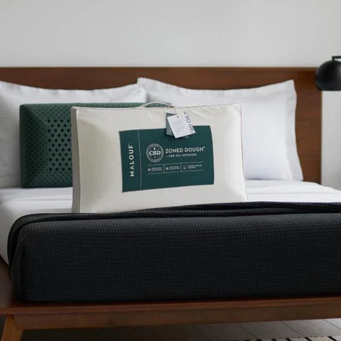 Malouf Zoned Dough CBD pillow on bed with luxury bedding, Egyptian cotton sheets, and dark blanket