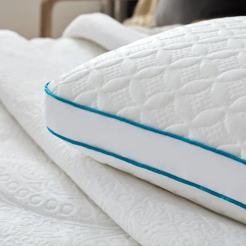 White quilted pillow with teal trim on Egyptian cotton bedding