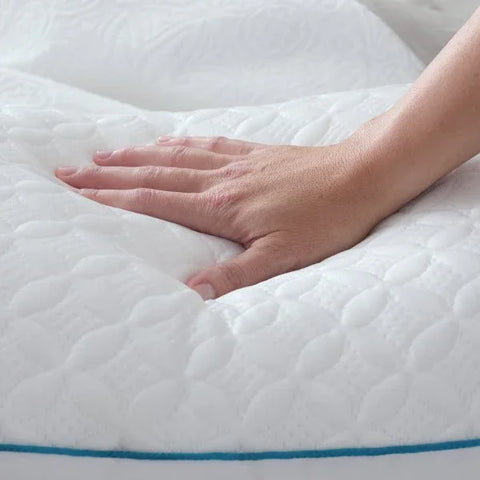 Soft white quilted mattress topper with hand pressing into plush surface, showing comfort and support