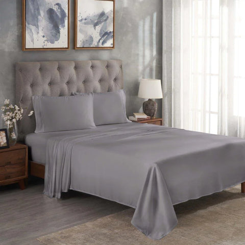 Gray Egyptian cotton bed sheets and pillowcases on a tufted bed with modern decor
