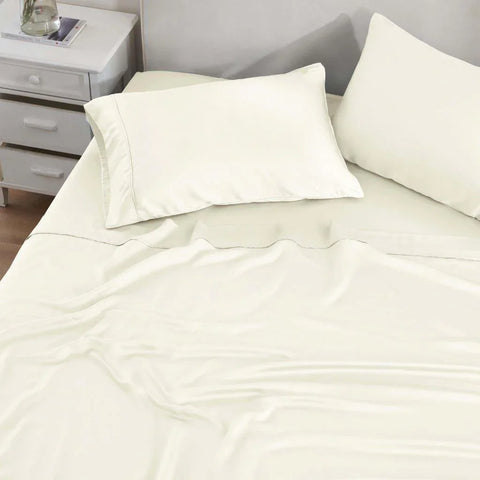 Cream Egyptian cotton bed sheets and pillowcases on a neatly made bed with subtle stitching detail