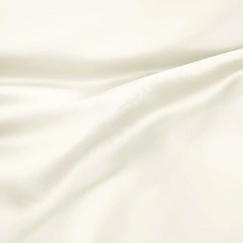 Luxury Egyptian cotton bed sheet in soft ivory, smooth texture with elegant drapes